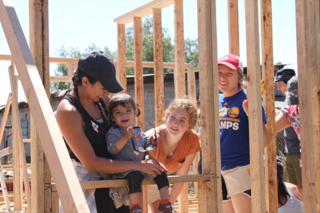 People standing in new home frame during construction